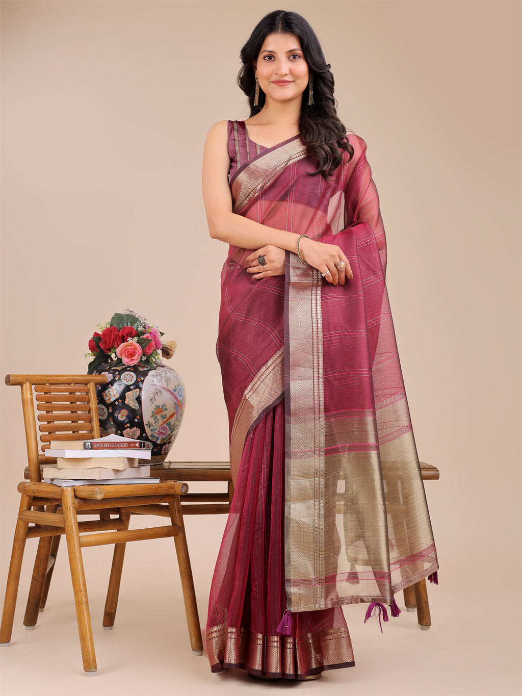 Magenta organza saree featuring detailed woven gold zari work and traditional tassels
