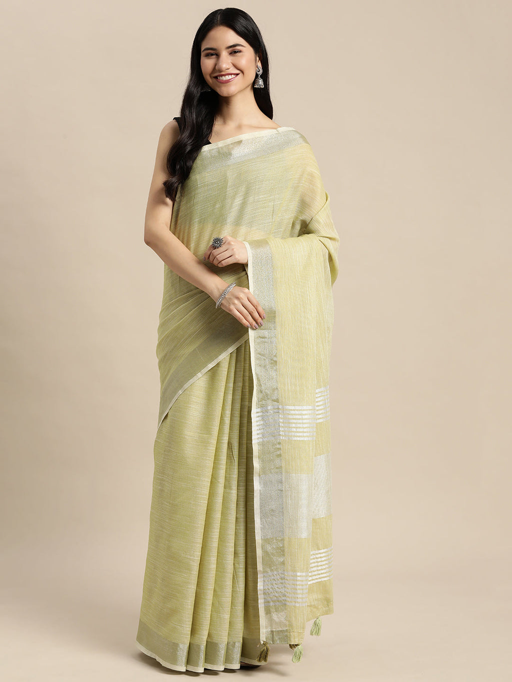 A Mehndi colored woven linen saree with a contrast gold zari border and decorative tassels.