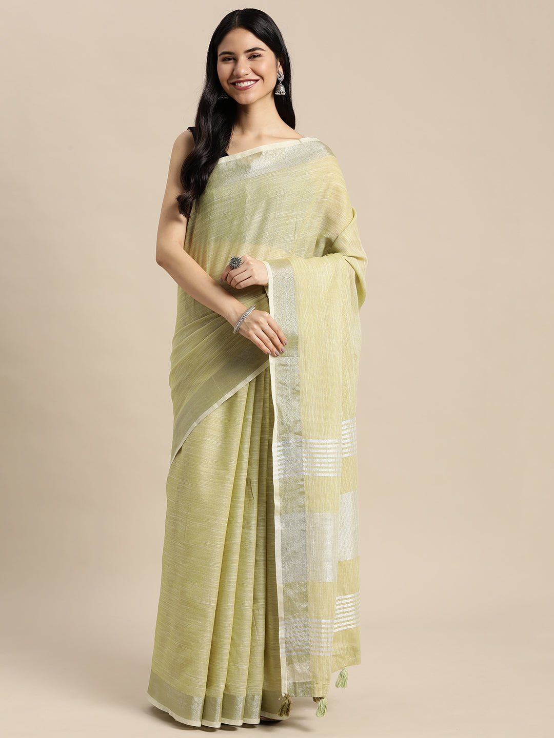 A Mehndi colored woven linen saree with a contrast gold zari border and decorative tassels.