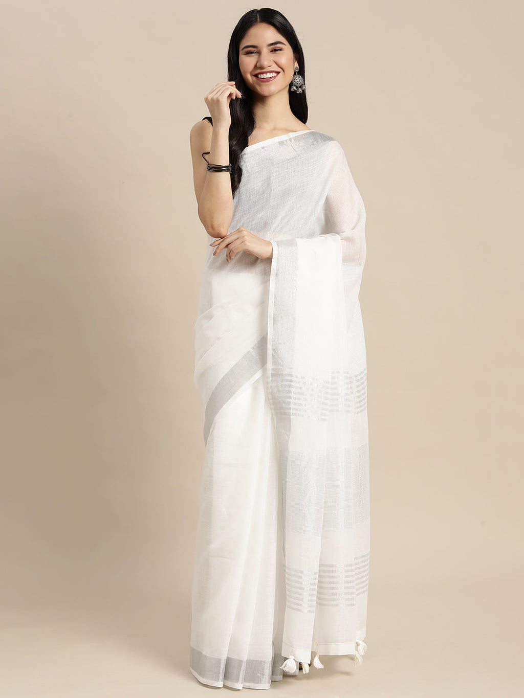 Elegant white linen saree with contrast zari border and decorative tassels