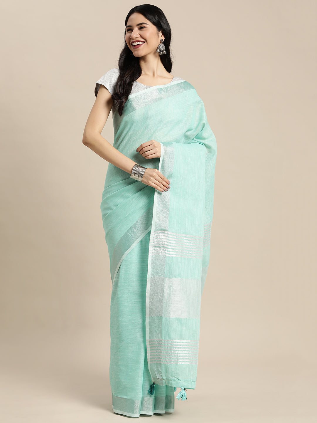 Elegant turquoise woven linen saree with contrast zari border and decorative pallu tassels