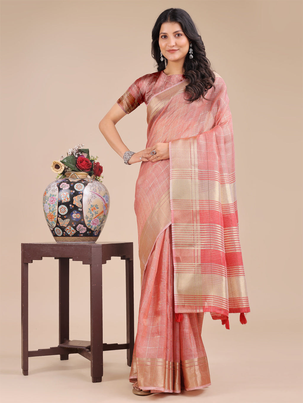 Peach organza saree with intricate woven zari borders and elegant tassel finishing
