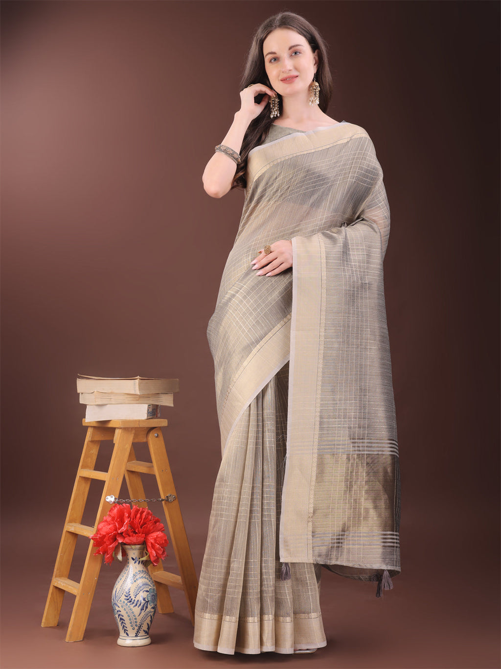 Woman wearing a beige organza saree with gold checked patterns for formal events