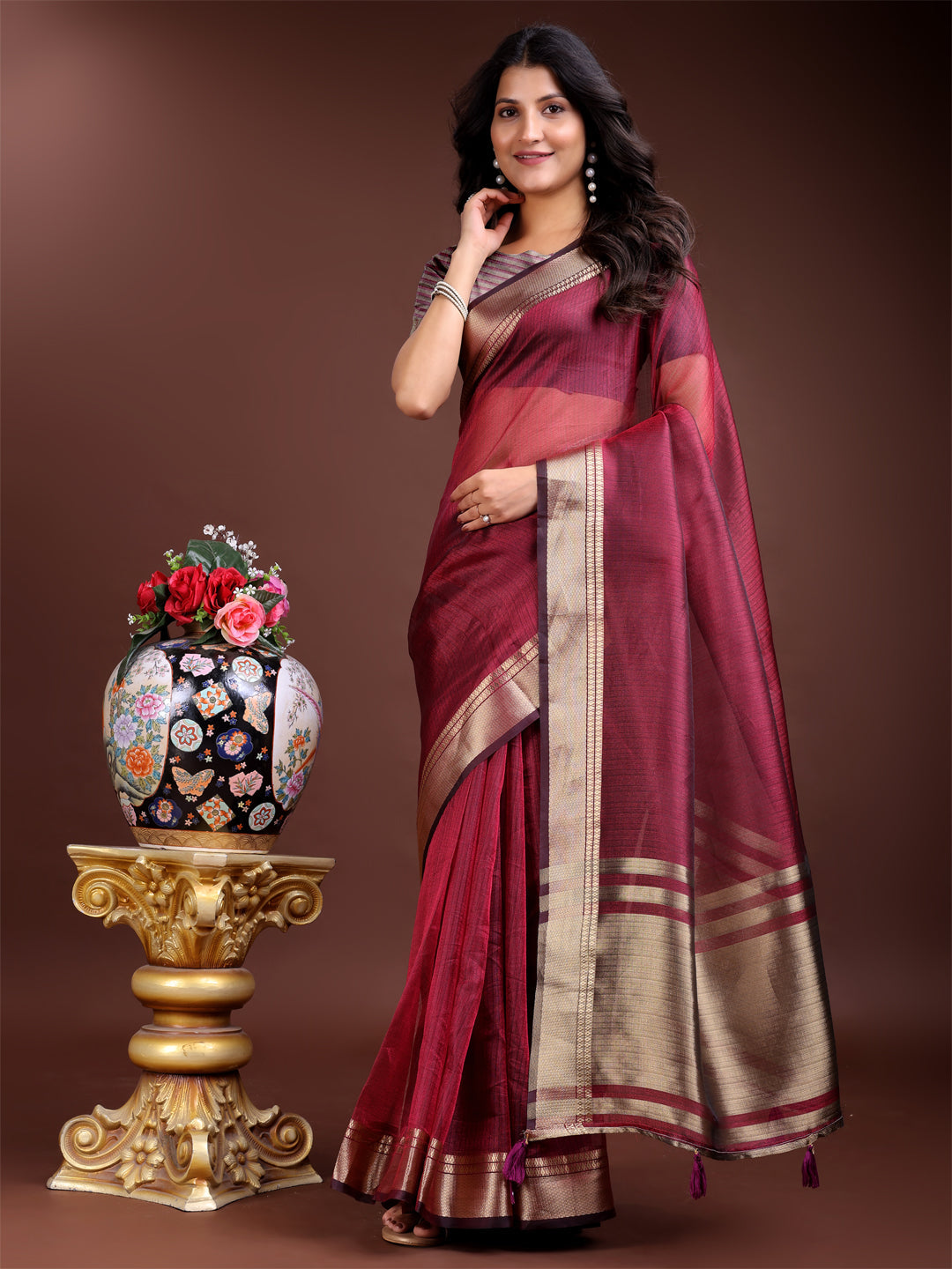 Magenta organza saree with woven zari embroidery and traditional tassels