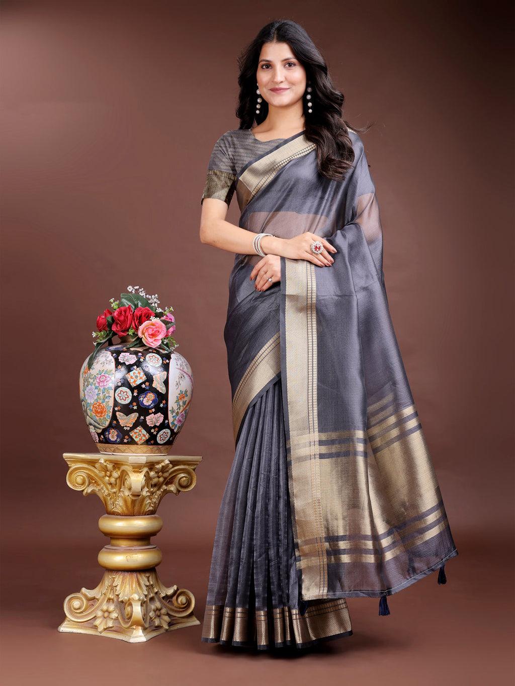 Elegant Grey organza saree featuring woven zari patterns and stylish tassels.