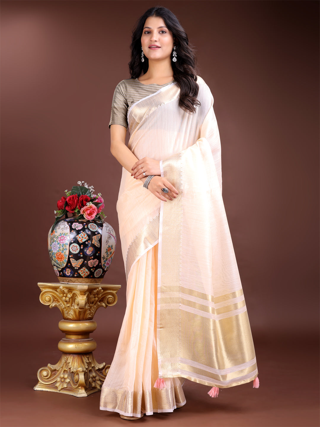 Peach woven linen saree with contrast zari border and decorative tassels