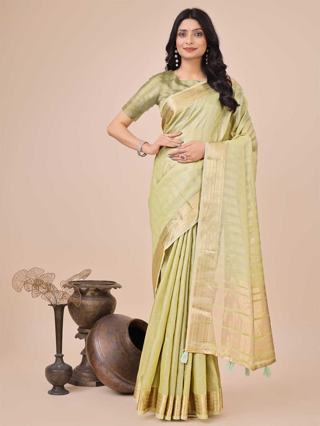 Light green organza saree with woven zari work and traditional tassels