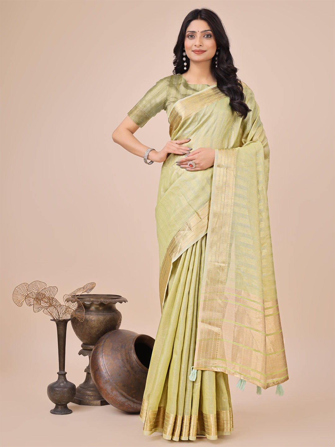Light green organza saree with woven zari work and traditional tassels