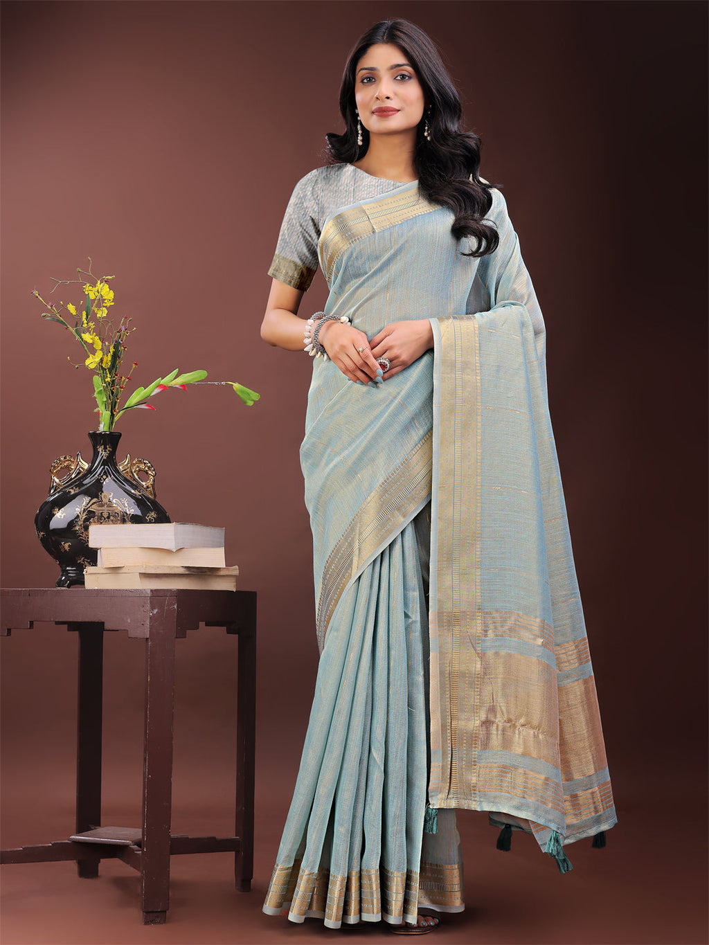 Sky blue organza saree with a traditional golden zari border and matching pallu