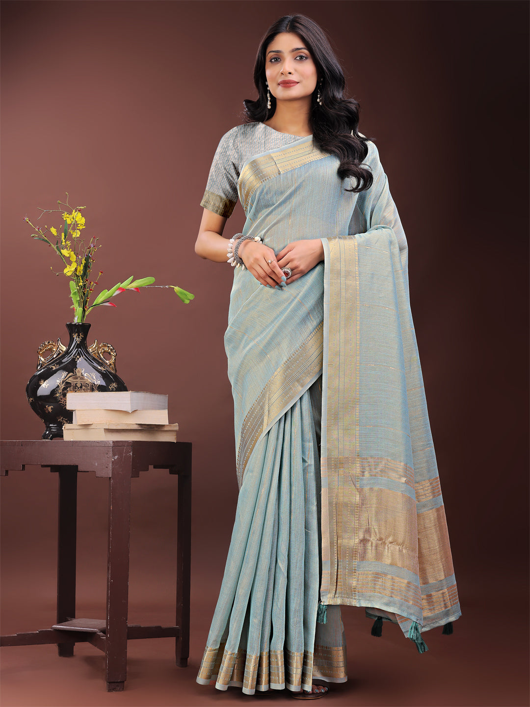 Sky blue organza saree with a traditional golden zari border and matching pallu