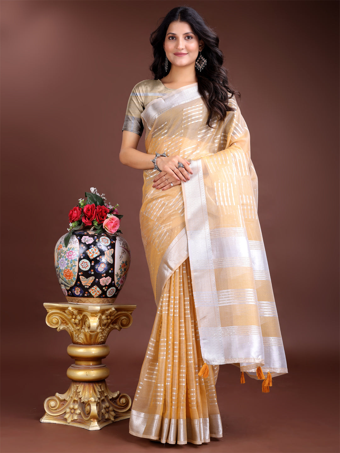 Bright yellow organza saree with intricate woven zari borders and tassels