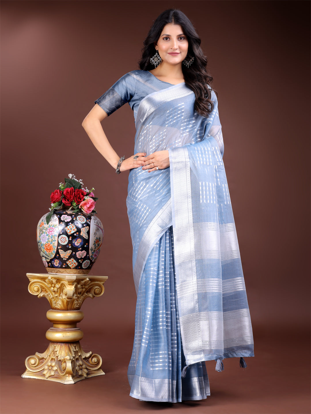 Sky blue organza saree with woven zari work and traditional tassels