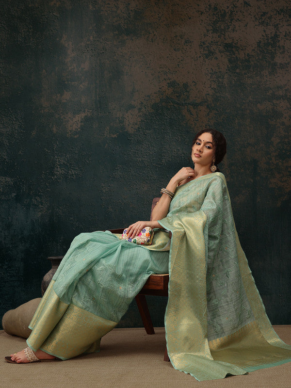 Green Kota Doria saree with delicate floral embroidery and unstitched blouse piece.