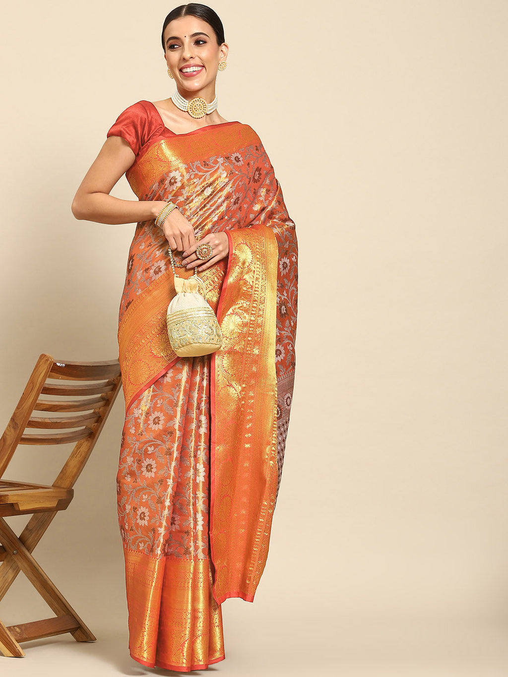 A beautiful red Kanjeevaram art silk saree with detailed floral zari woven patterns.