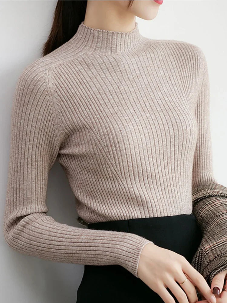 Close-up view of a woman wearing a slim-fit, long-sleeve mock neck ribbed sweater in a neutral beige color.