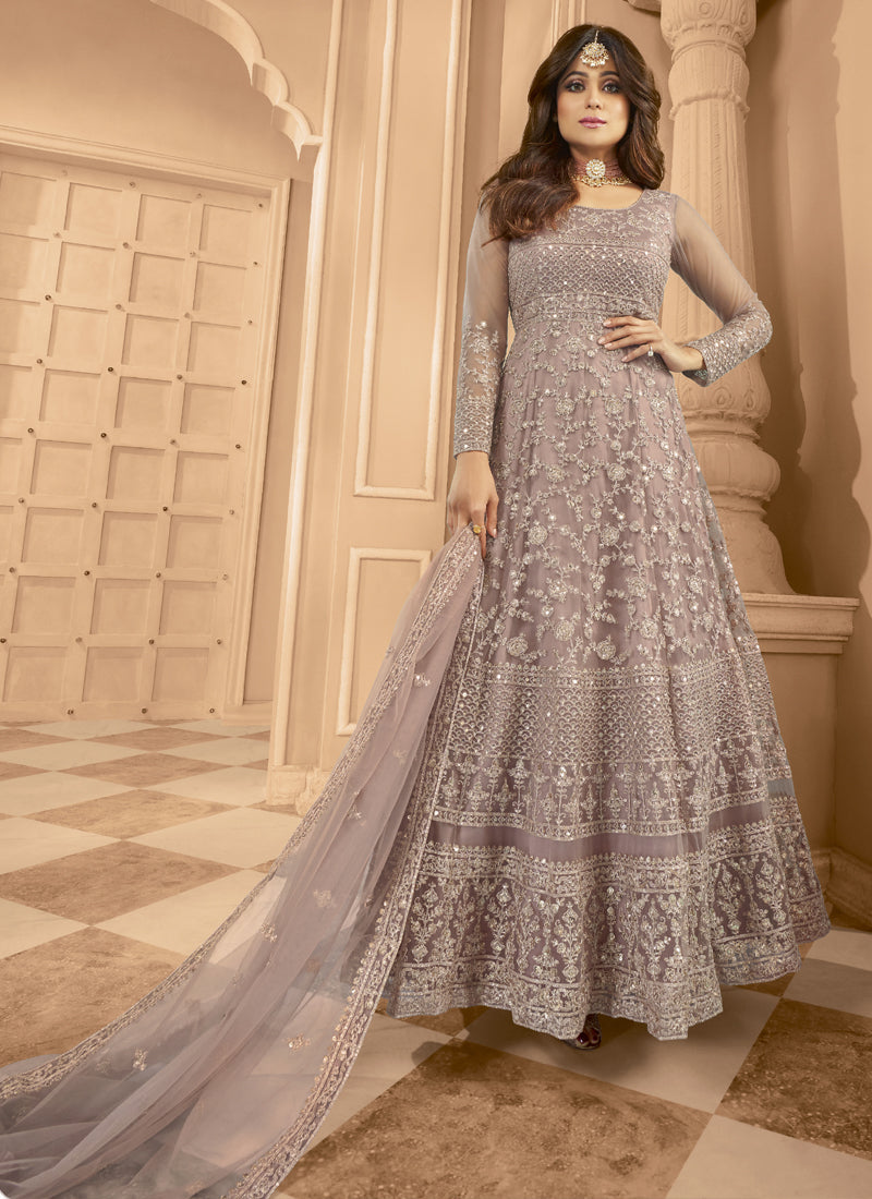 Model wearing an Onion Pink Net Anarkali suit with detailed embroidery and matching dupatta