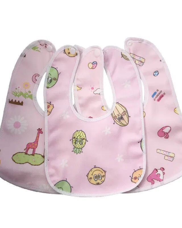 Three baby bibs with colorful patterns on a pink background