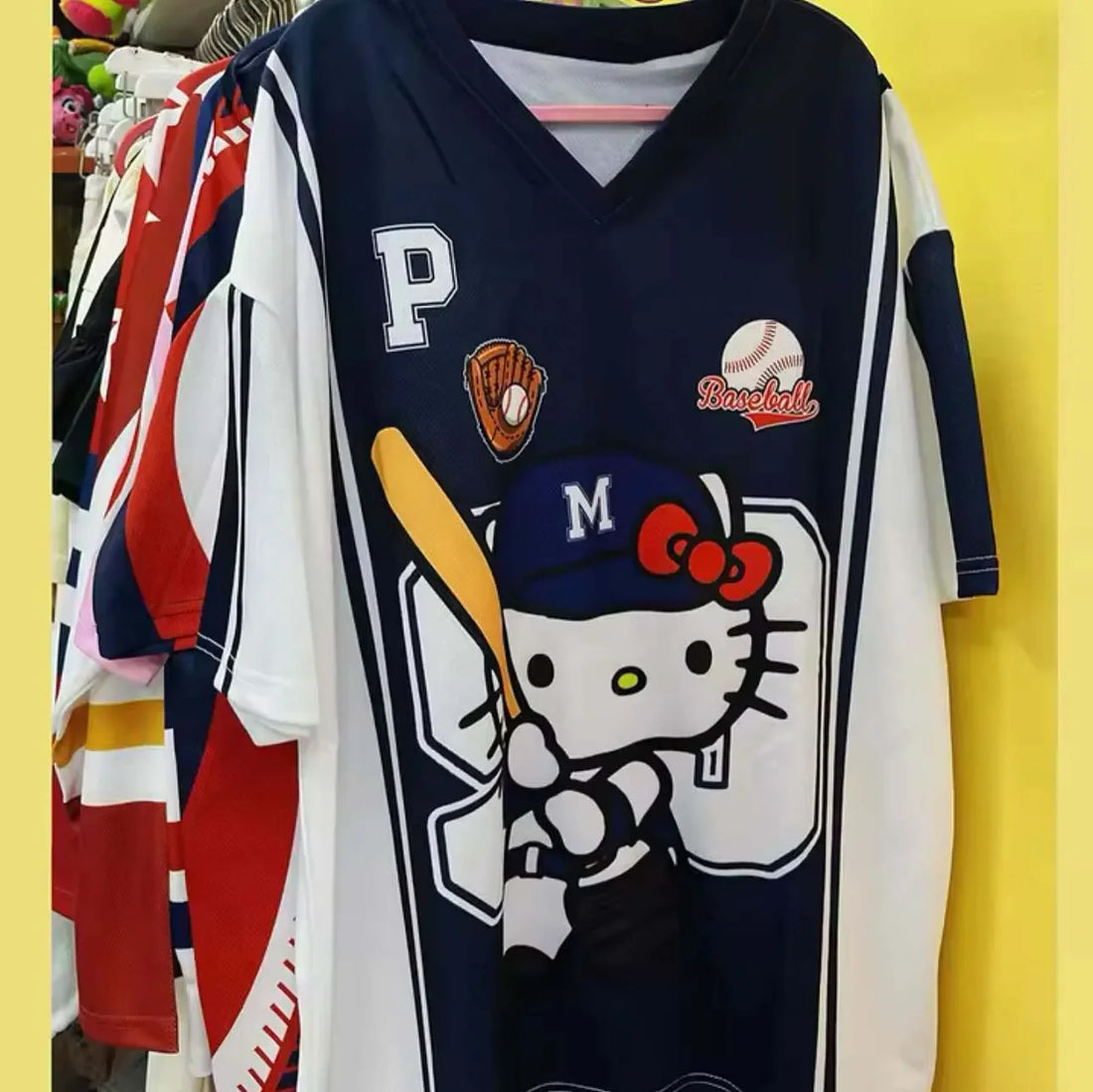Women wearing a navy blue or pink baseball-themed graphic T-shirt with a v-neck