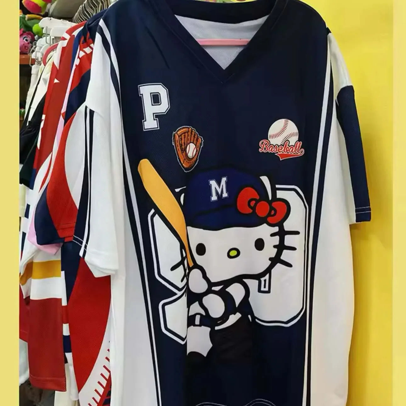 Women wearing a navy blue or pink baseball-themed graphic T-shirt with a v-neck