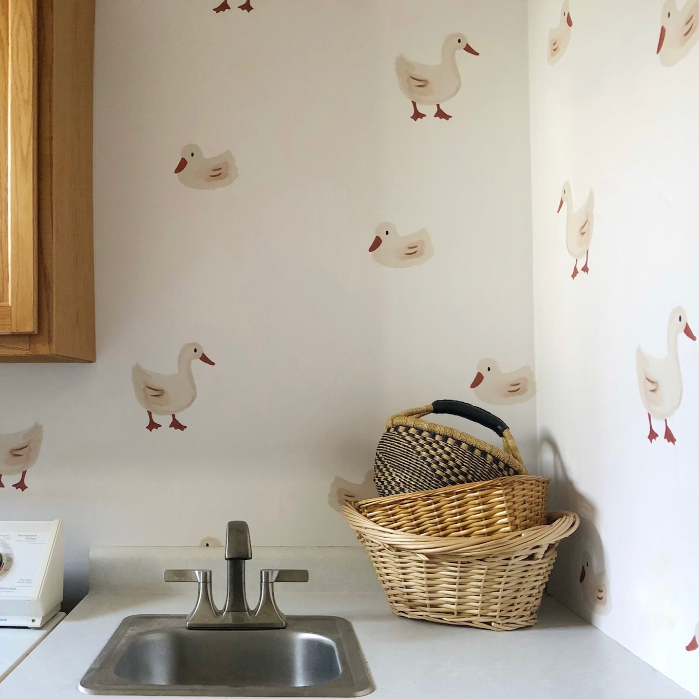 Daffy whimsical wallpaper with orange, cream, and off-white colors in a nursery
