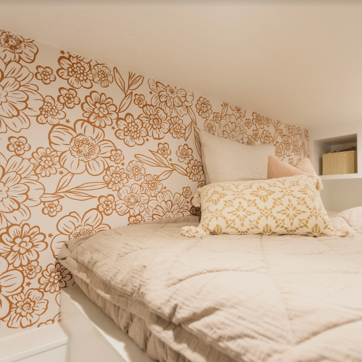 June floral pattern wallpaper in cream and terracotta colors on a living room wall