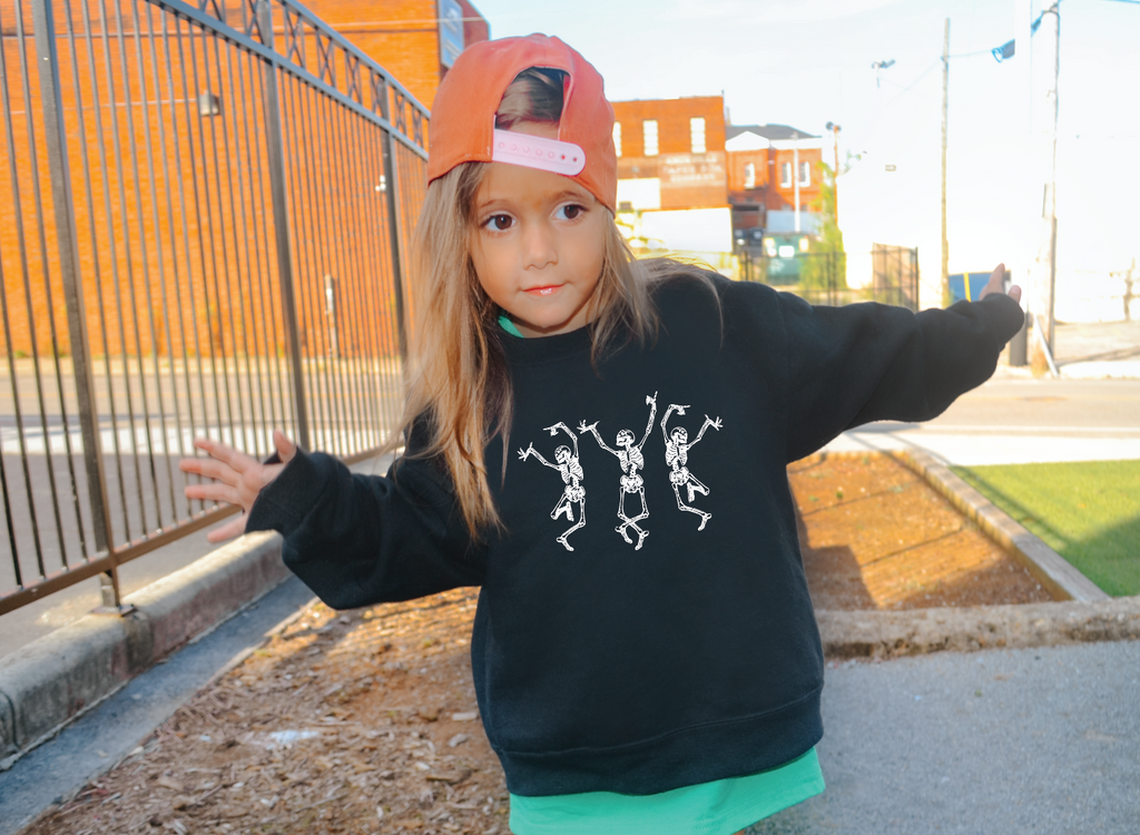 Unisex black and white sweatshirt featuring tan dancing skeletons graphic