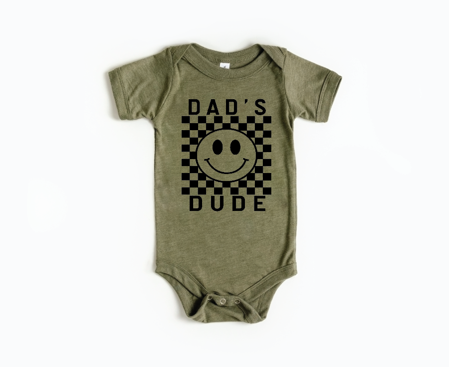 Checkered plaid baby onesie in olive green, black, white, and cream.
