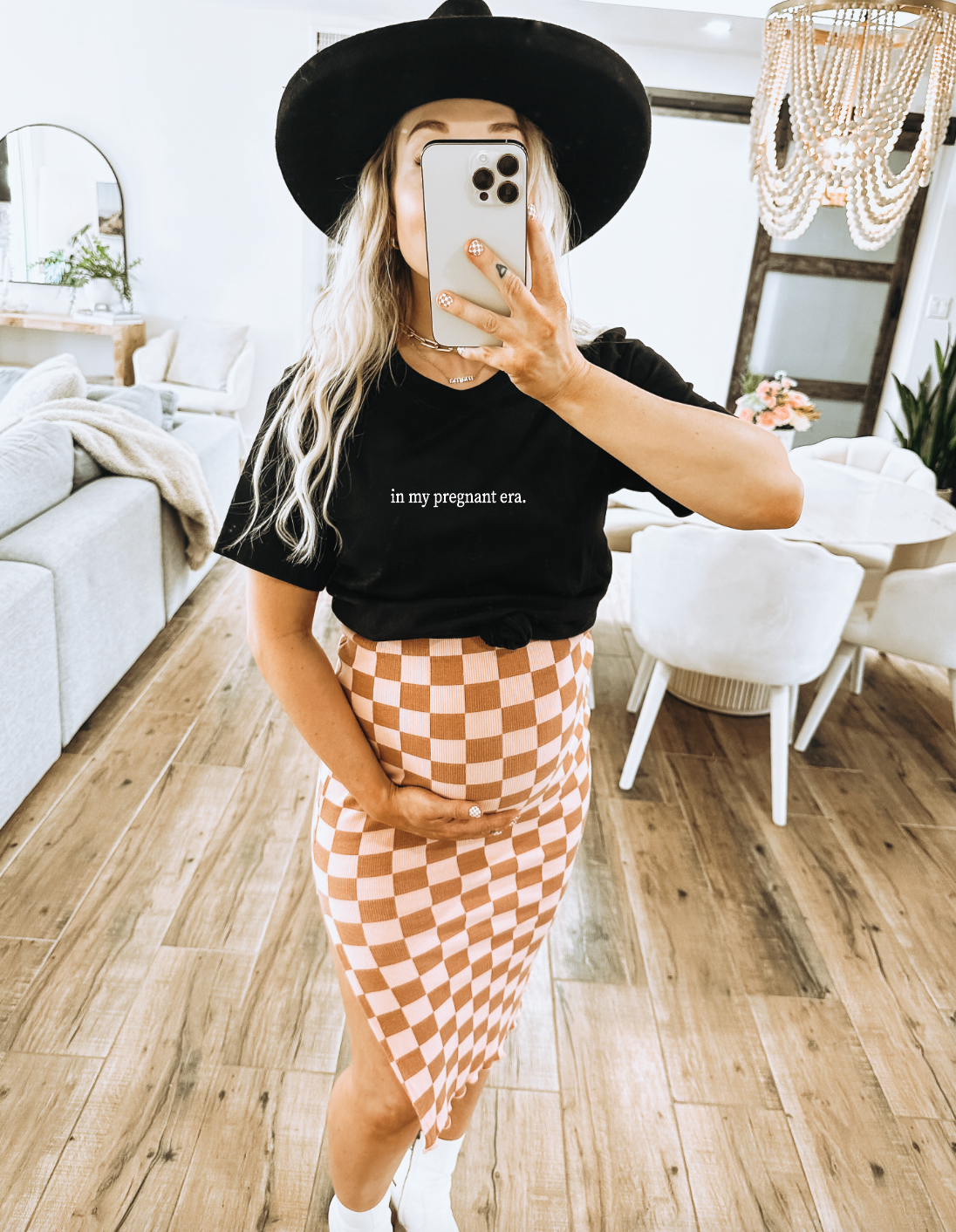 Woman wearing an In My Pregnant Era minimal graphic tee in white
