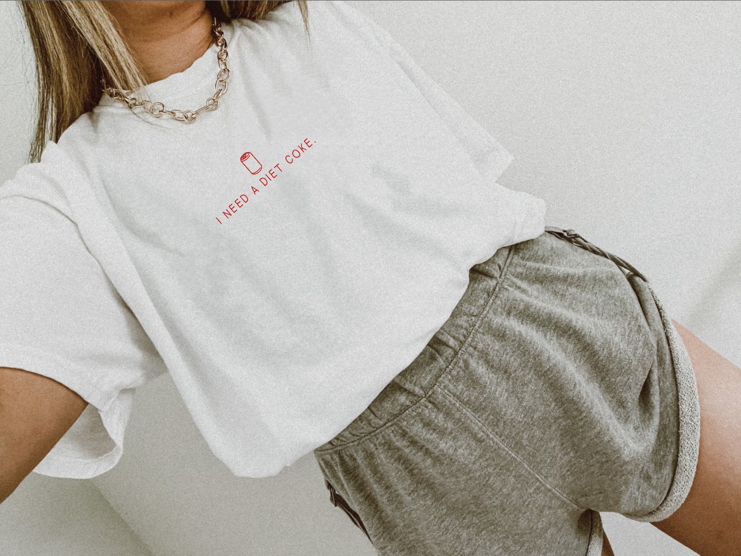White and red I Need A Diet Coke graphic top.
