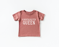 Little girl wearing a Kindergarten Queen graphic tee in dusty-rose
