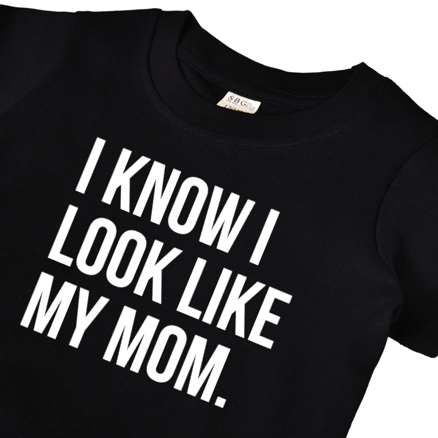 Child wearing a grey graphic t-shirt that reads I know I look like my mom