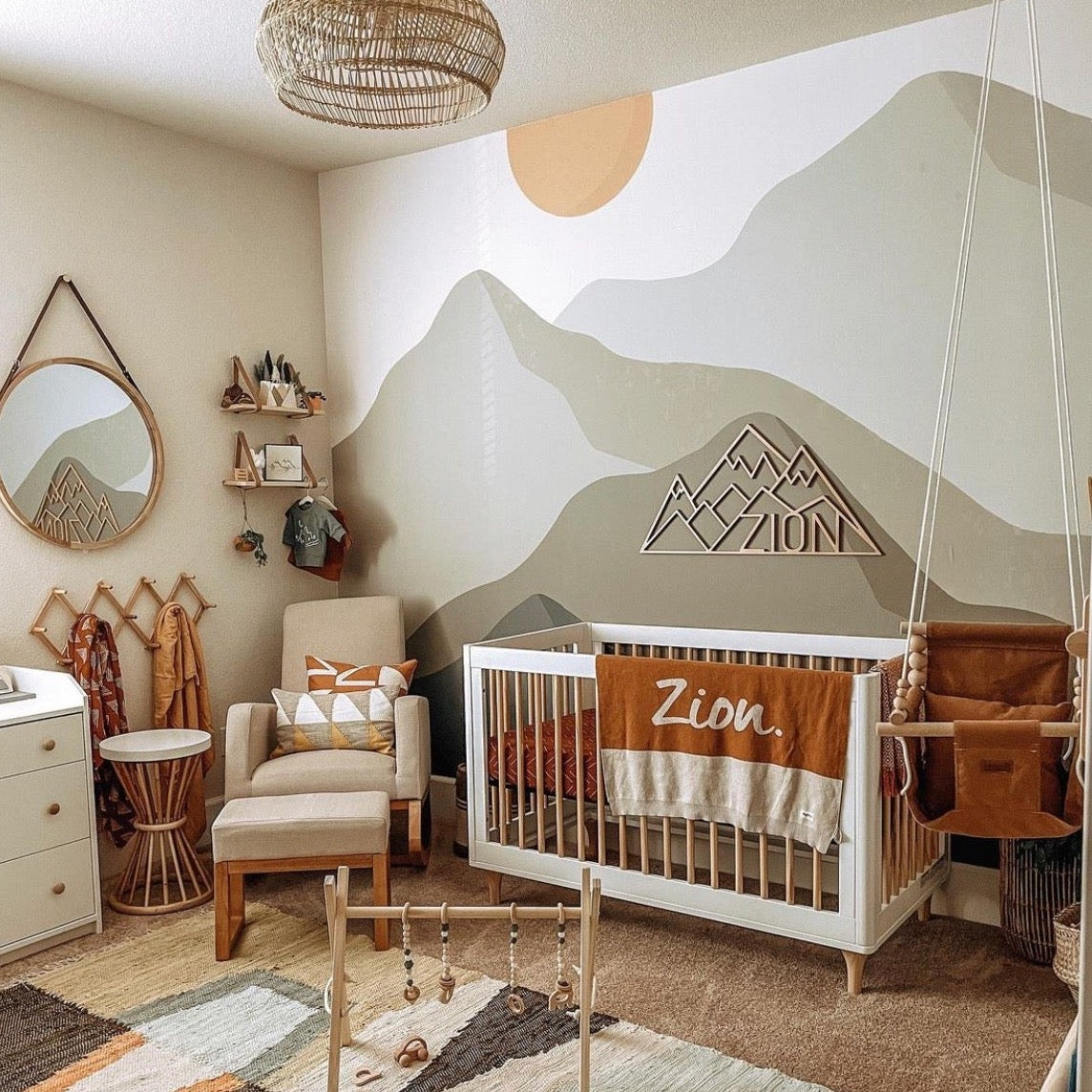 Ender abstract wallpaper in sage green, cream, and terracotta tones on a nursery wall
