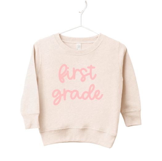 Child wearing a First Grade Girly Pullover in a casual, preppy knit style.
