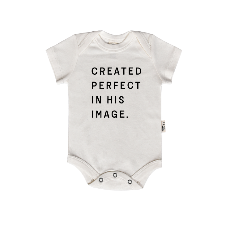 A soft cotton baby onesie in Black or Natural with the text Created Perfect in His Image printed on the front.