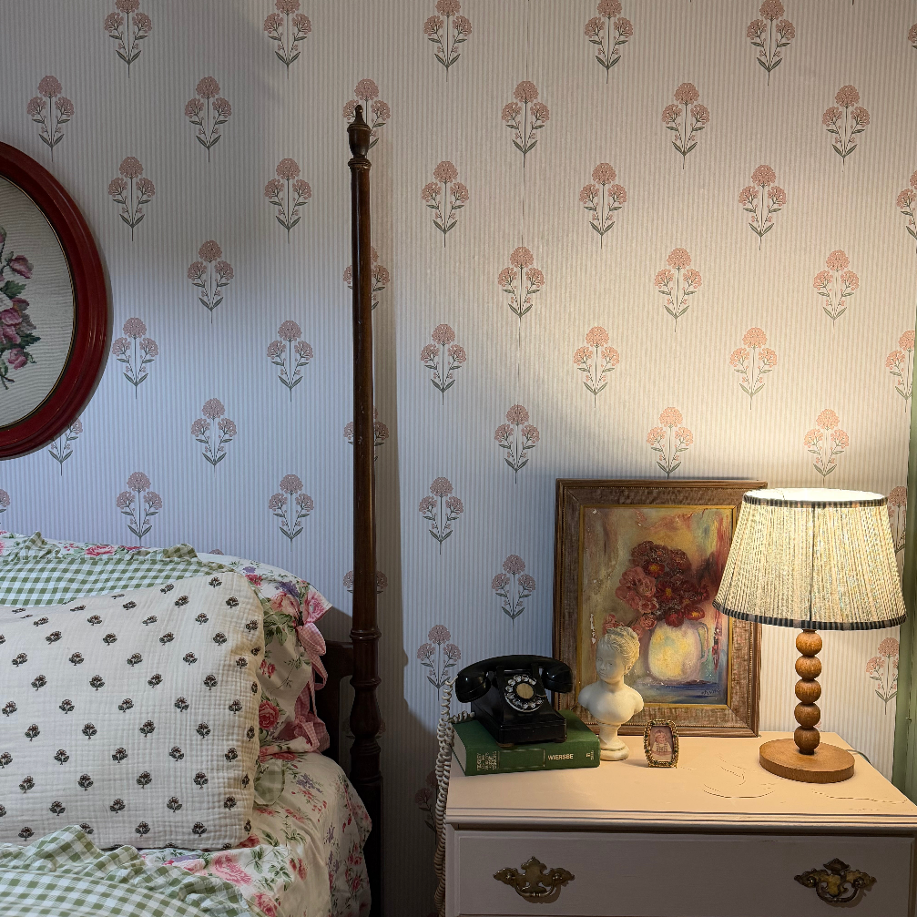 Susannah floral pattern wallpaper in cream, pale-pink, and sage-green on a bedroom wall