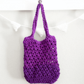 A colorful crocheted tote bag made from purple, green, and white t-shirt yarn.