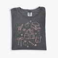 A collection of Back to School Doodles graphic t-shirts in various colors including pink and black.