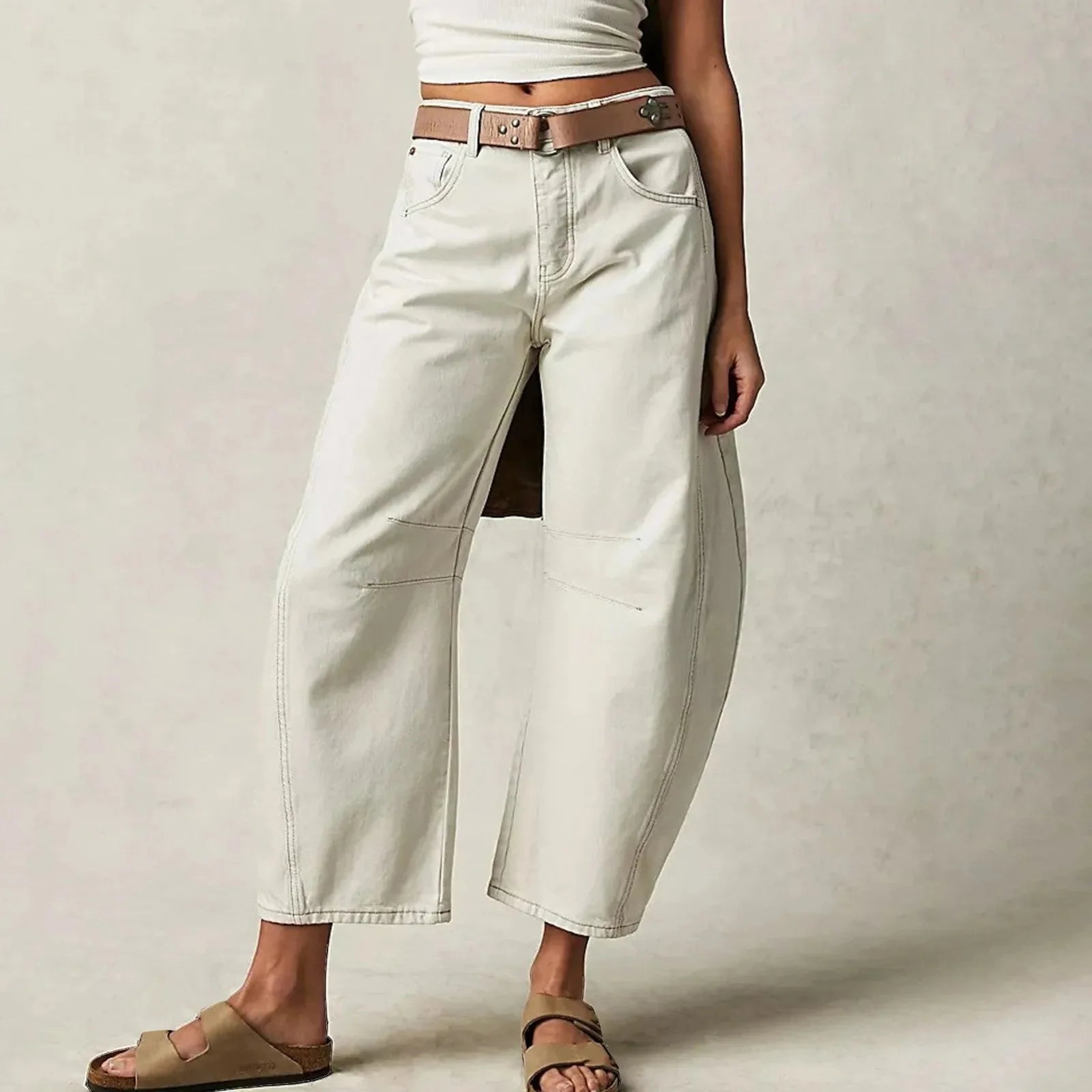 Model wearing mid-waist baggy wide-leg Y2K style jeans in khaki tan on a beach background
