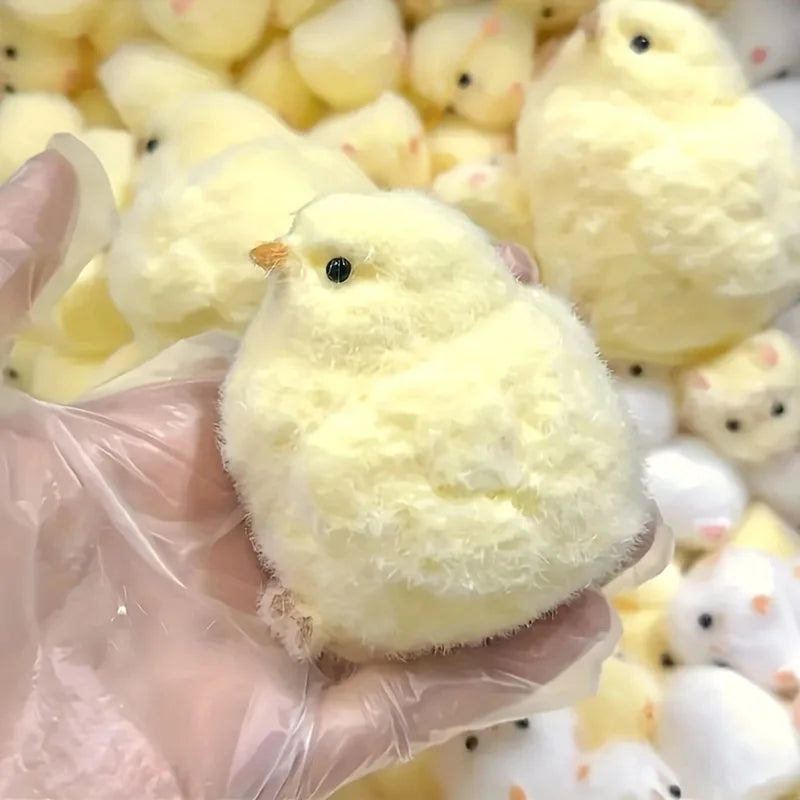 A soft yellow chick squishy squeeze fidget toy held in a hand, featuring a round, fluffy appearance.