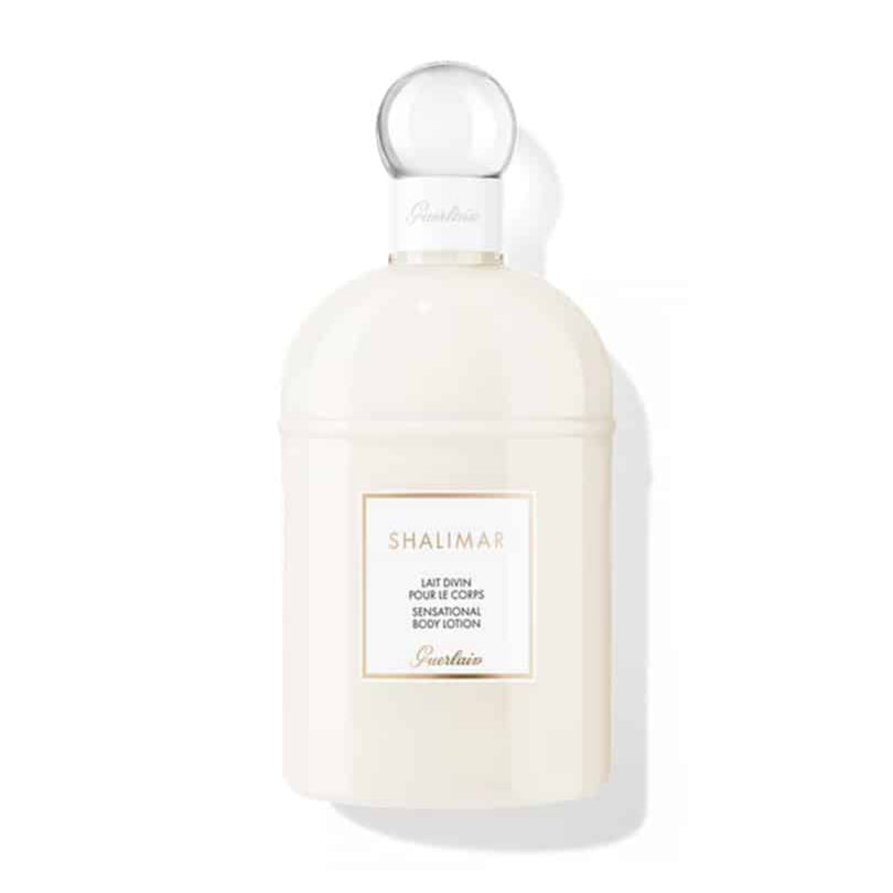 Guerlain Shalimar Sensational Body Lotion in a creamy white bottle with gold accents.