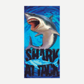 A rectangular beach towel featuring a large, detailed shark with an open mouth and text reading SHARK ATTACK over a blue water-pattern background.