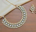 A premium white Kundan neckpiece with a copper base, styled for traditional ethnic attire.