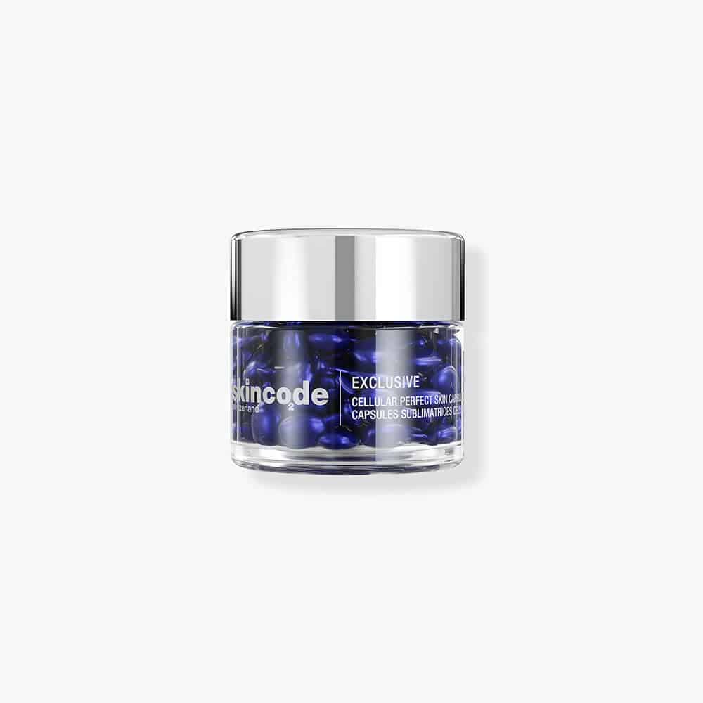 Skincode Cellular Perfect Skin Capsules in a clear glass jar with a silver cap, featuring deep royal blue serum capsules.