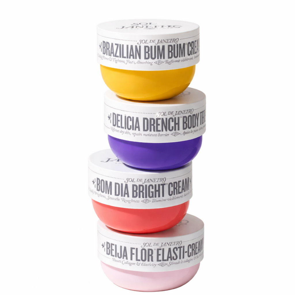 A collection of four Sol de Janeiro body creams and butters in colorful jars arranged for a skincare ritual.