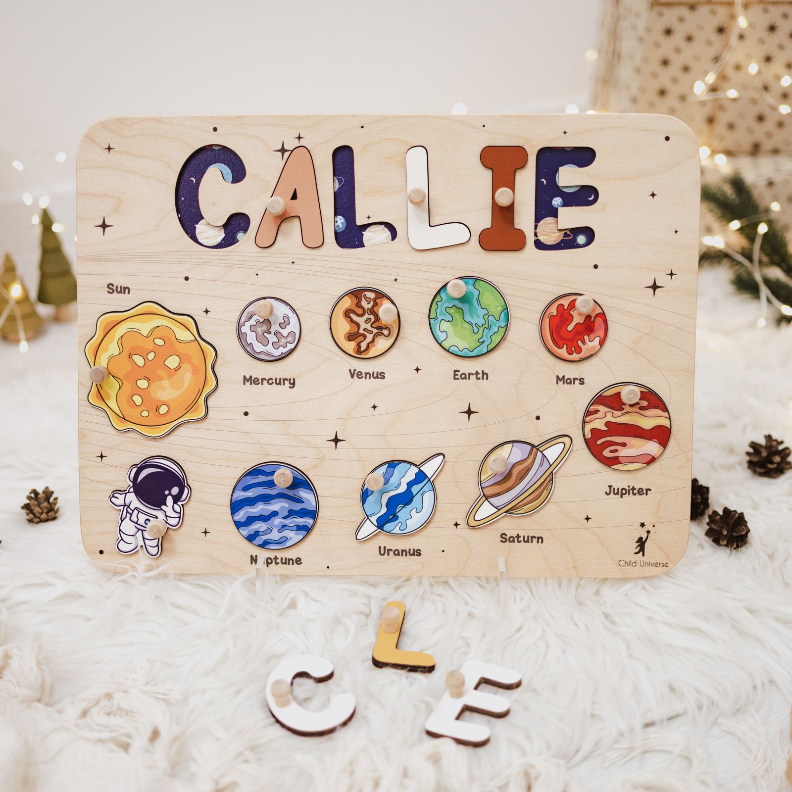 Wooden Solar System name puzzle wall art on a neutral bedroom wall featuring planets and child's name
