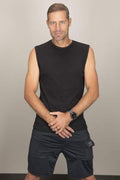 Man wearing a black ribbed muscle tank top in a gym setting