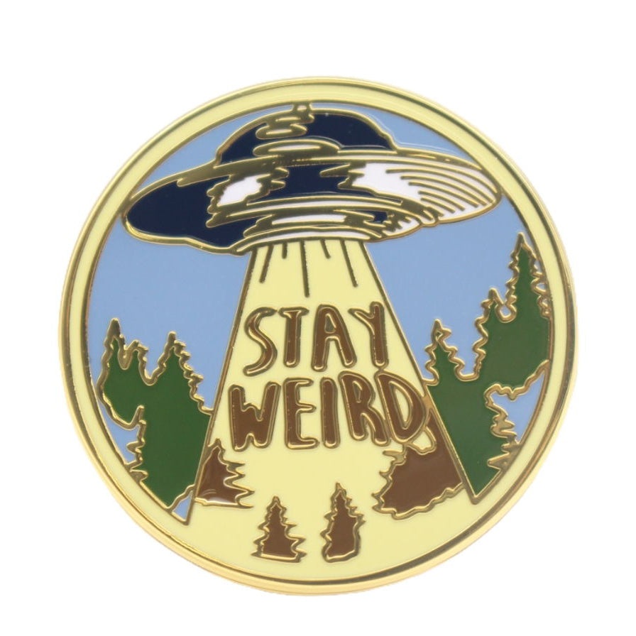 Circular Stay Weird enamel pin with bright colors and gold trim