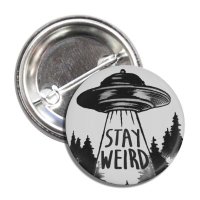 Round monochromatic black and white Stay Weird button pin on a plain background