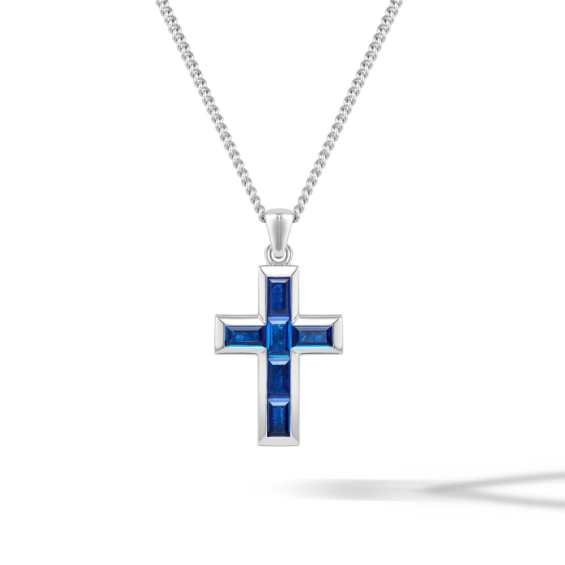 Close up of a minimalist Sapphire Gemstone Cross Pendant crafted in 925 sterling silver
