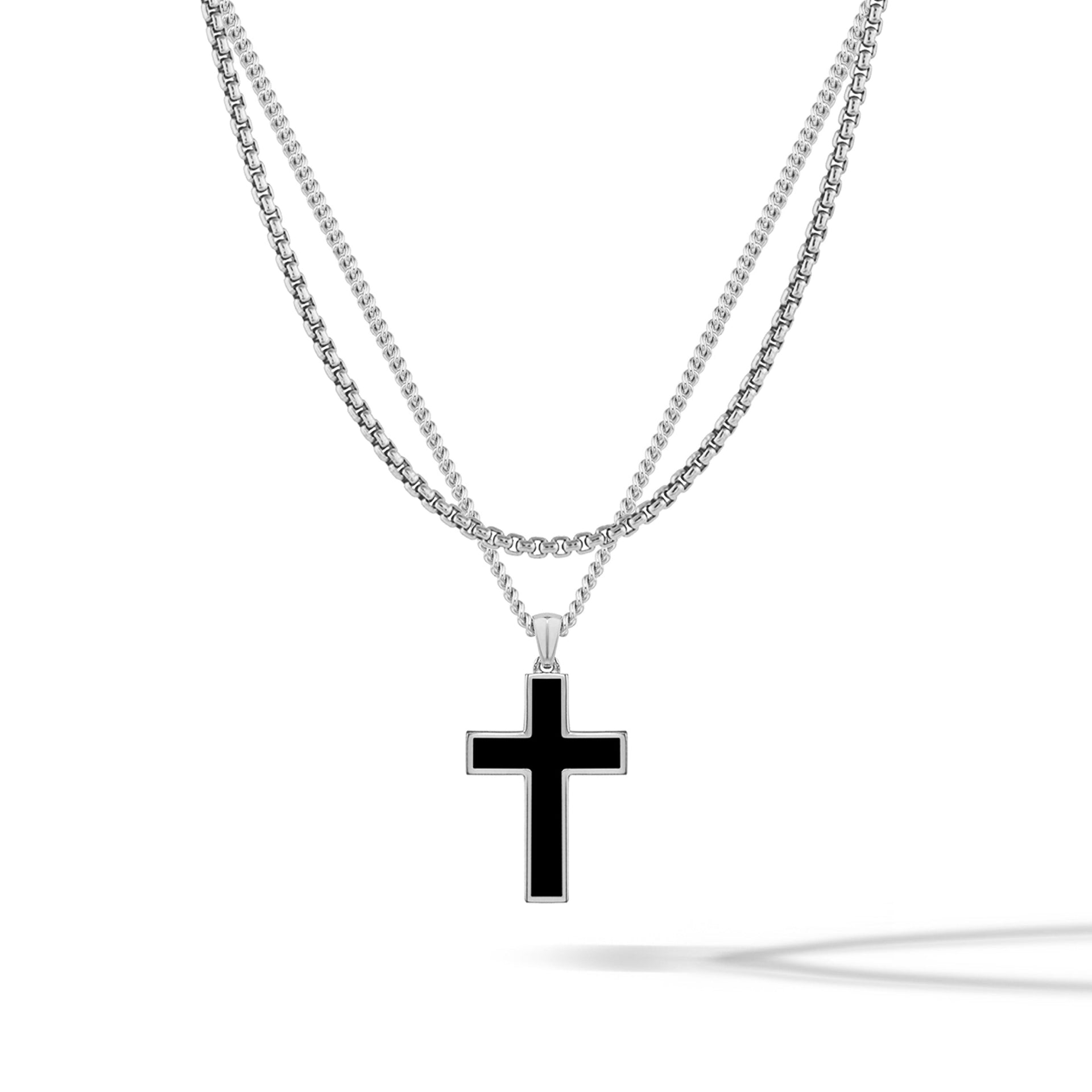 Sterling silver cross pendant hanging on a matching silver box chain.